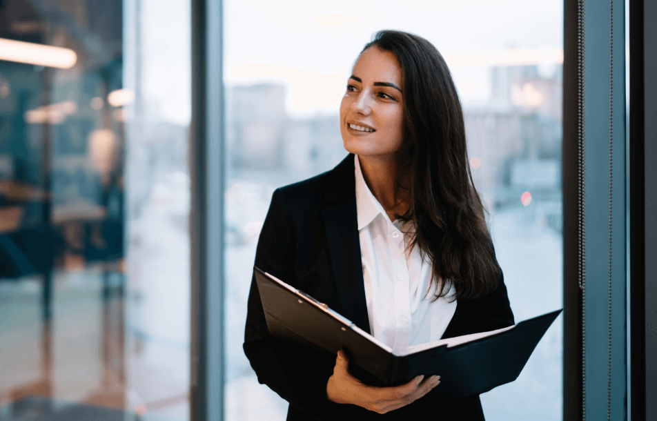 positive-businesswoman-with-folder-standing-in-mod-2024-05-13-17-00-36-utc